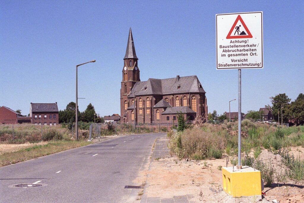 Ein Bild von einer einsamen Backsteinkirche. Die Häuser um den Kirchenplatz herum sind alle abgerissen worden.